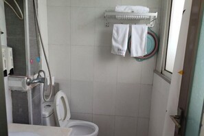 A small bathroom with a toilet, a shower area, and a towel rack with two towels. - Hanlin Business Hotel (Huaibei)