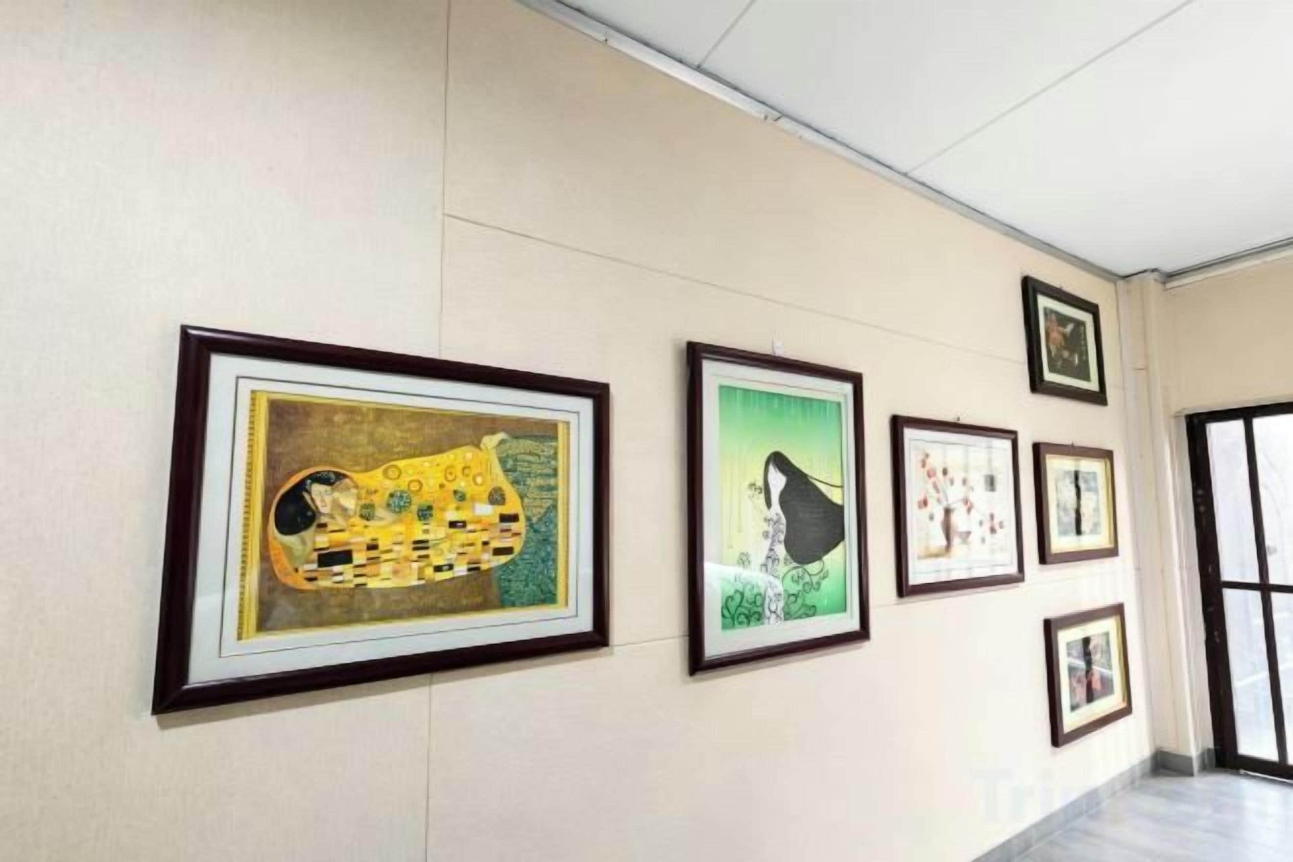 A hallway with framed artworks on the wall.