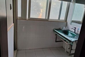 A small, clean bathroom with a single sink, a mirror, and a window. - Hanlin Business Hotel (Huaibei)