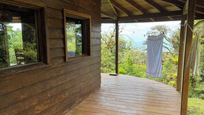 Una cabaña de madera con terraza de madera y porche cubierto.