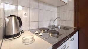 A compact kitchen with a kettle, two electric kettles, a sink, and a glass ashtray. - Apartment in Brodarica by Sandy Beach (Sibenik)
