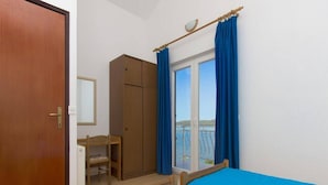 A bedroom with a bed, a desk, a wardrobe, and a window with curtains. - Apartment in Brodarica by Sandy Beach (Sibenik)
