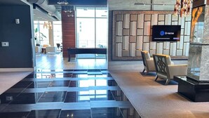 Um lobby moderno com piso xadrez, balcão de recepção e logotipo U-verse na parede.