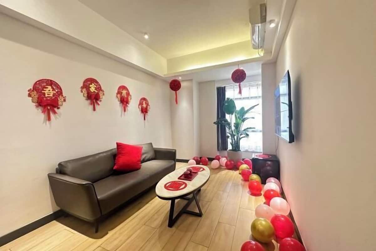 Una sala de estar moderna con un sofá, una mesa de centro y detalles rojos en las paredes.