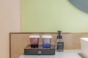 Ein Badezimmer mit Waschtisch, zwei Seifenspendern und einer Handdesinfektionsmittel-Flasche.