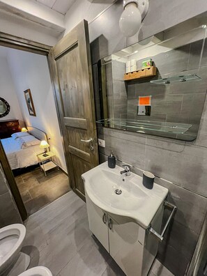 A modern bathroom with a sink, mirror, and toilet. - Vacation House by Anna and Turi (San Gavino ( frazione di Budoni))