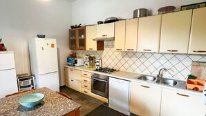 A compact kitchen with white cabinets, a gas stove, a sink, and a refrigerator. - Villa da Anna e Turi - 5 minutes from the beach (San Gavino ( frazione di Budoni))