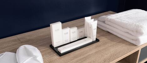 A wooden table with a white towel and a display of personal care products.