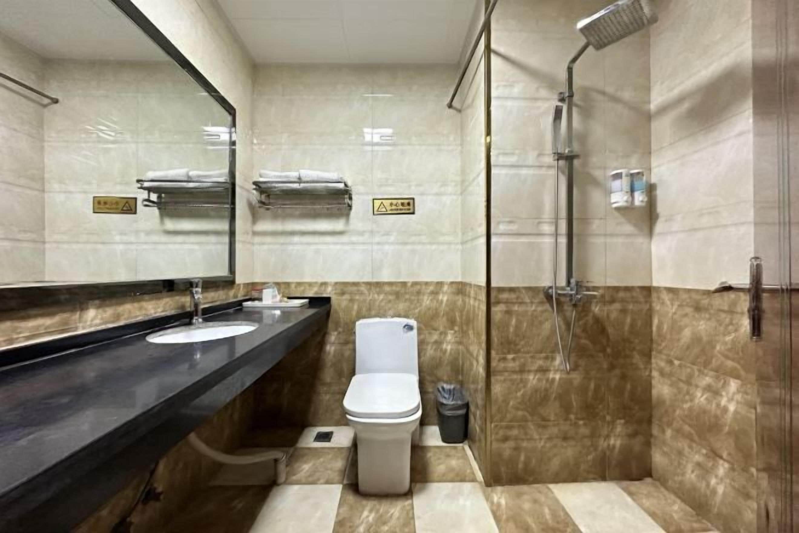 Un baño moderno con lavamanos, inodoro y ducha.