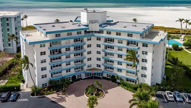 Een hotel met meerdere verdiepingen, een zwembad en uitzicht op het strand.