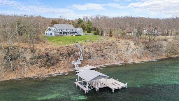 A waterfront property with a dock and a staircase leading to a house. - Lakefront 6BR Retreat with Private Dock, Huge Deck & Epic Seneca Views (Dundee)