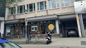 Monikerroksinen rakennus, jossa on katutasossa myymälätila nimeltä ”Filia”. Rakennuksessa on lasijulkisivu ja kyltti, joka osoittaa parkkialueen.