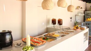 A buffet setup with various food items, a black pot, and hanging wicker lamps. - Hotel Rodadero Beach Blue (Santa Marta)