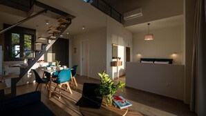 Un intérieur moderne comprenant un coin repas, une cuisine et un escalier menant à un niveau supérieur.