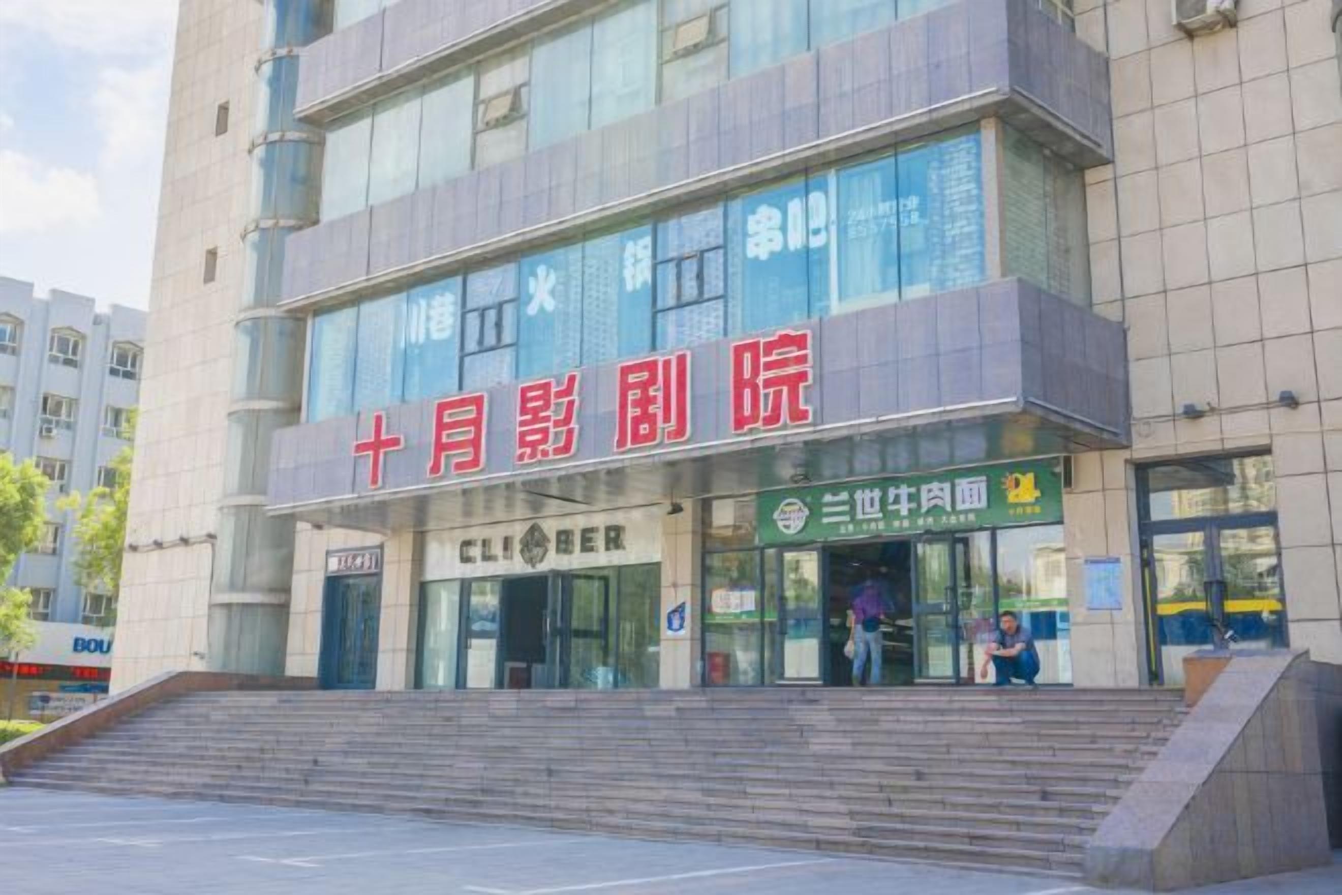 A multi-story building with a prominent red sign indicating a cinema.