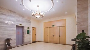 A spacious lobby with a marble floor, a chandelier, and a large wooden door. - Vienna Classic Hotel (Nanjing Nanzhan Jiangning Wanda Plaza) (Nanjing)