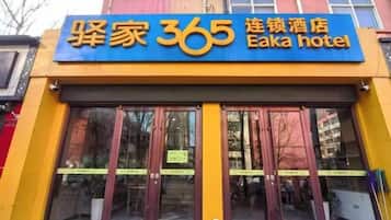 Entrada de un hotel con un cartel llamativo que dice 'Whimsy 365 Eika hotel'.