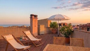 A rooftop terrace with lounge chairs, a table, and potted plants. - Láttic, Terres de lébre Biosphere Reserve (La Ràpita)