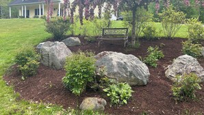 A garden with a bench, large rocks, and flowering trees. - Beautiful, private getaway, close to all New England attractions (Hampton Falls)