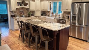 A spacious kitchen with a large island, stainless steel appliances, and a view of the outdoors. - Beautiful, private getaway, close to all New England attractions (Hampton Falls)