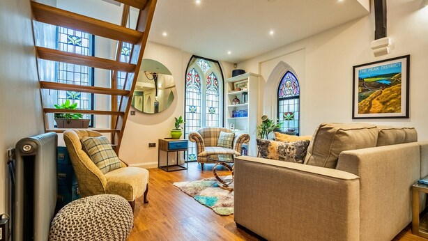 A living room with a sofa, armchairs, a ladder, a radiator, and a bookshelf. - Apartment in Matlock Near Peak District (Matlock)