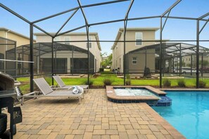 Zona de piscina con jacuzzi, sillas de descanso y una parrilla.
