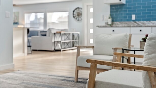 Una sala moderna con un sofá, una mesa de centro de madera y una alfombra.