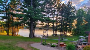 A lakeside patio with outdoor seating and a walking path. - Lakefront Lodging, Beach, Fire Pit, Bar & Grill, Rentals, Live Music, Trails (Tomahawk)