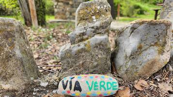 Un monumento de piedra con una roca pintada que dice "VIA VERDE" en un entorno natural.