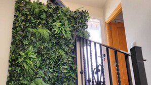 A staircase with a black railing and a wall covered in green foliage. - Cozy house in the heart of Caudiel, 100 meters from the greenway Ojos Negros. (Caudiel)
