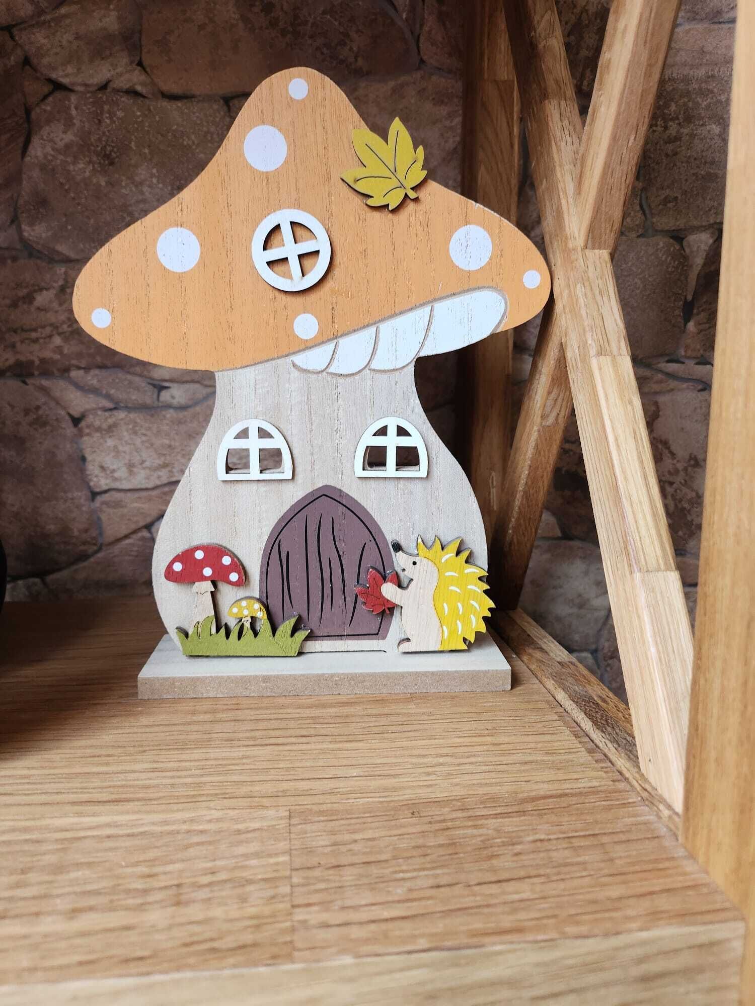 Uma casa de madeira em miniatura com teto de cogumelo, uma porta e um ouriço.