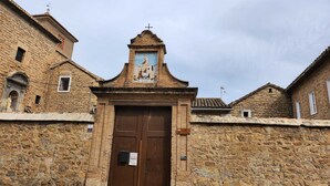 A stone building with a central entrance, a small bell tower, and a religious mural above the entrance. - Cozy house in the heart of Caudiel, 100 meters from the greenway Ojos Negros. (Caudiel)