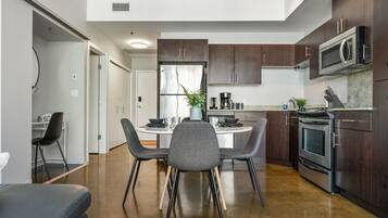 A modern kitchen with dark wood cabinets, stainless steel appliances, and a central island with seating.