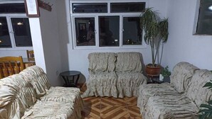 A living room with patterned sofas and a wooden parquet floor.
