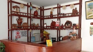 A reception desk with a wooden structure and shelves displaying various items.