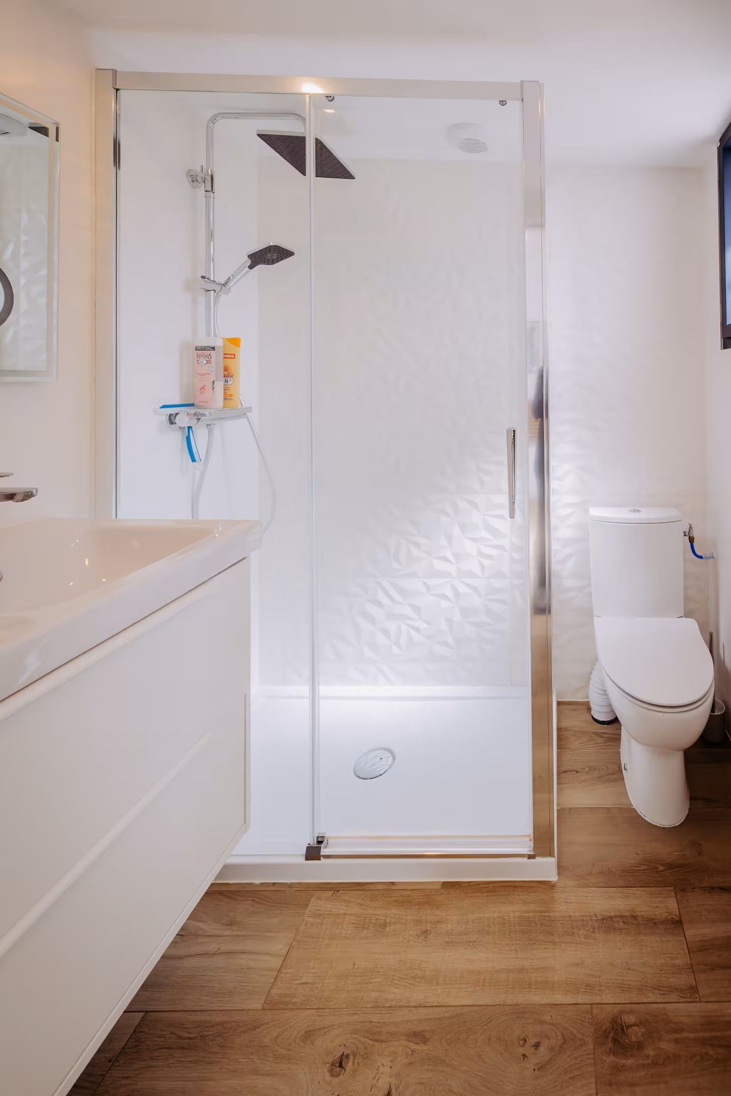 Une salle de bain moderne avec une douche à parois de verre, des toilettes et un lavabo.