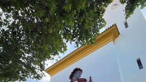 A building with a white facade and a red and gold entrance. - Charming relax 2 bedroom apartment 200 meter to beach and 15 min bus city center (Málaga)