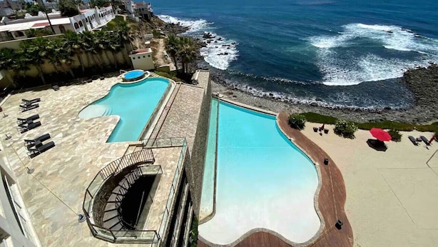 A resort with a large pool area, a staircase leading to a rooftop, and a view of the ocean. - Las Olas Grand 3br Luxury- Beach, Pools, Hot tubs (Rosarito)