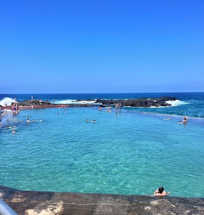 Guests can swim and relax in the expansive pool overlooking the ocean.