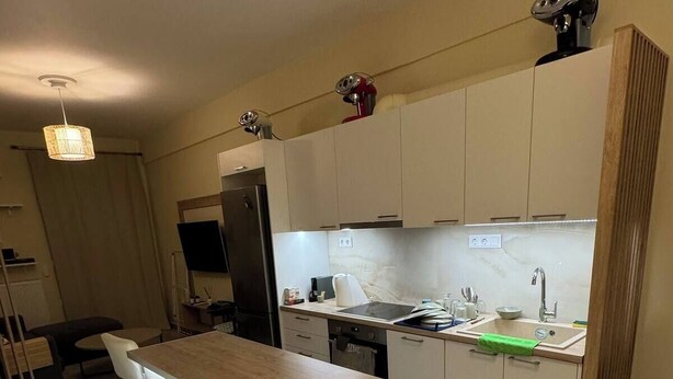 A modern kitchen with a central island, bar stools, and a dining area. - the New lovely Athens Central apartment (Athina)