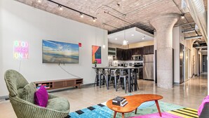 A modern interior with a green chair, a wooden coffee table, and colorful rugs.