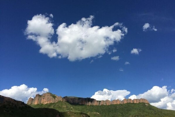 A mountain landscape with a clear sky and clouds.