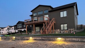 Una casa moderna de dos pisos con balcón y cimientos de piedra.