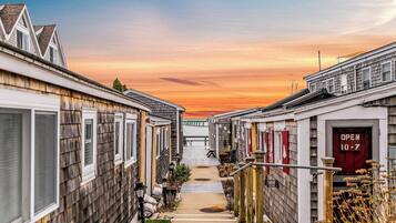 A row of wooden houses with a pathway leading to a gate.