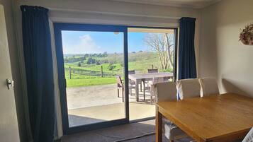 A room with a large sliding glass door leading to an outdoor area with a table and chairs.