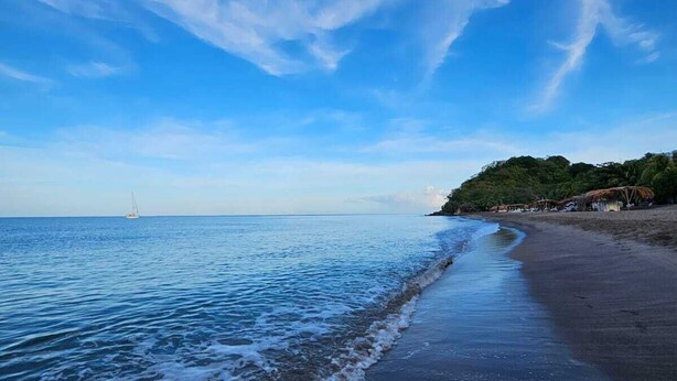 A beach with a clear sky and calm sea.