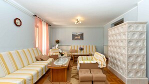 Ein Wohnzimmer mit gestreiften Sofas, einem Couchtisch und einem dekorativen Schrank.