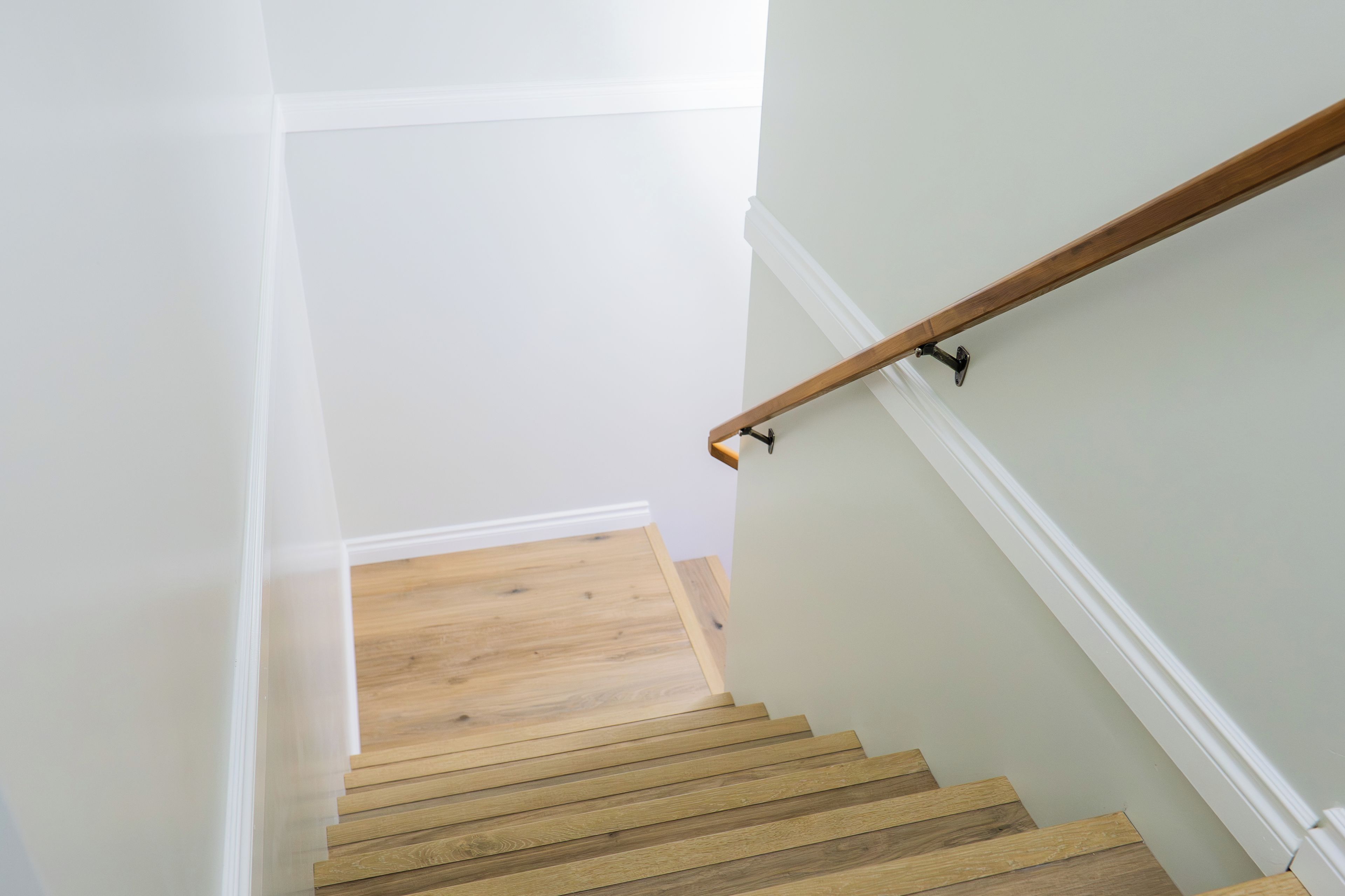 Un escalier avec des marches en bois et des murs blancs.