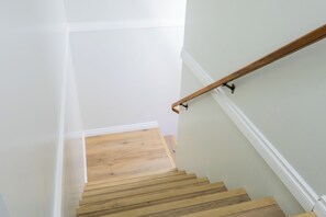 Eine Treppe mit Holzstufen und weißen Wänden.