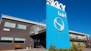 Un hotel con un llamativo letrero azul que dice "SKY hotel" y una fachada de edificio moderna.